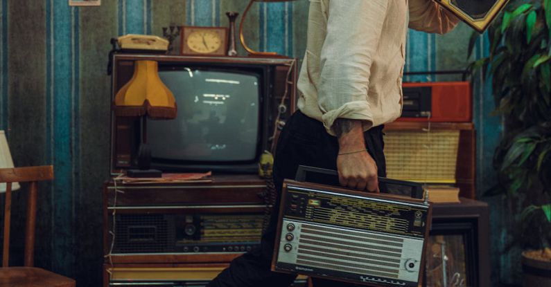 Vintage Appliances - A Man Holding Vintage Radio and Cassette Player