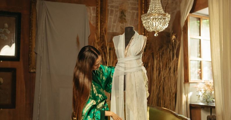 Vintage Patterns - A Woman in Green Kimono Standing Near the Mannequin in White Dress