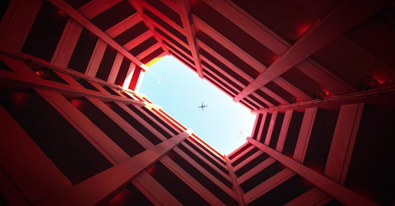 Focal Point - Low-angle Photography of Building Showing Airplane on Skies