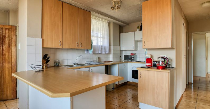 Kitchen Furniture - A kitchen with wooden cabinets and a white counter