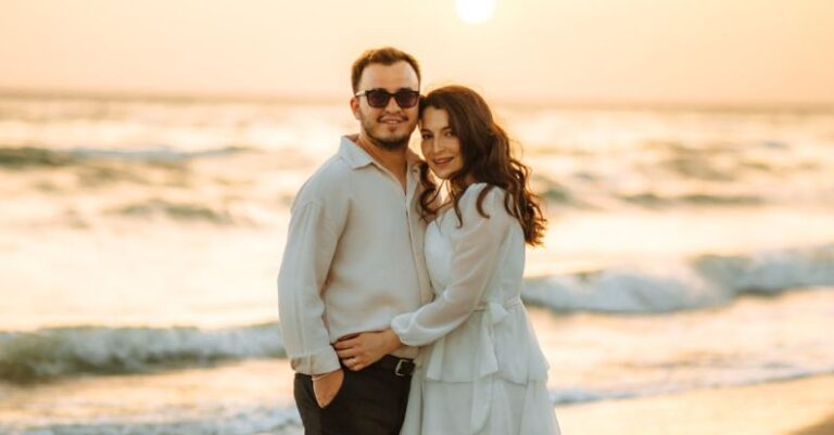 Gold Accents - A couple standing on the beach at sunset