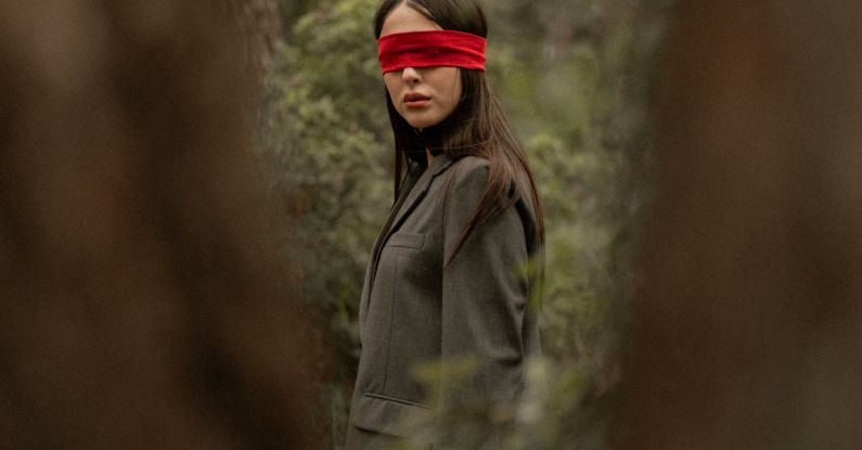 Vertical Space - A woman with a red blindfold in the woods