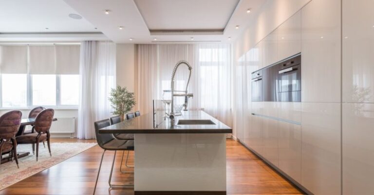 Kitchen Islands - Interior of spacious kitchen with modern minimalist furniture with built in appliances and dining zone in contemporary apartment in daylight