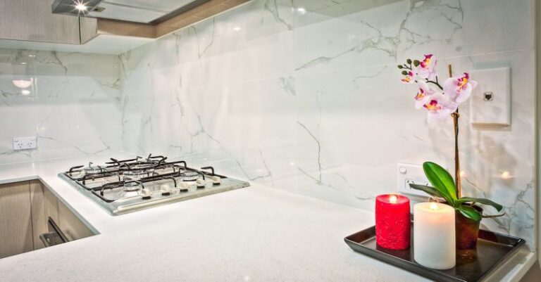 Backsplash - Two Light Red and White Pillar Candles Beside Pink Orchid Flowers in Kitchen